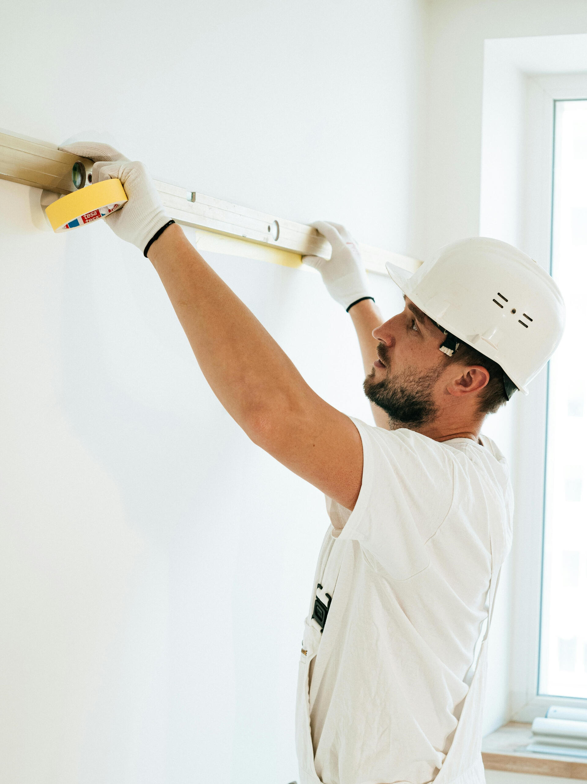 Schlafzimmer Handwerker Messarbeiten – Karl & Olaf Handwerker misst Wand im Schlafzimmer mit Maßband und Lineal